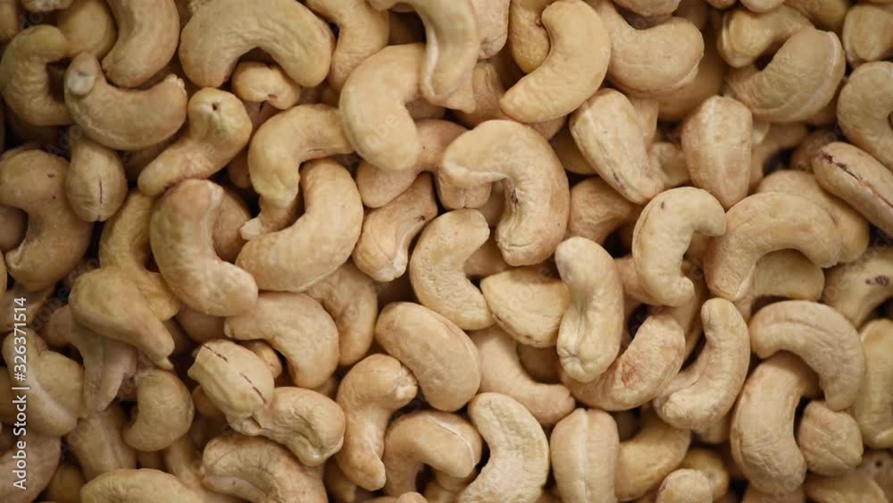 Cashew nuts on rotating background. Food ingredient background. Vegan, vegetarian diet. Healthy lifestyle. Natural dry fruits and nuts concept Cashew nuts on rotating background. Food ingredient background. Vegan, vegetarian diet. Healthy lifestyle. Natural dry fruits and nuts concept