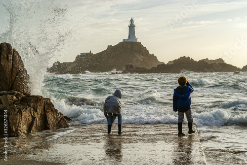 Kids playing at the sea - in front of the lighthouse