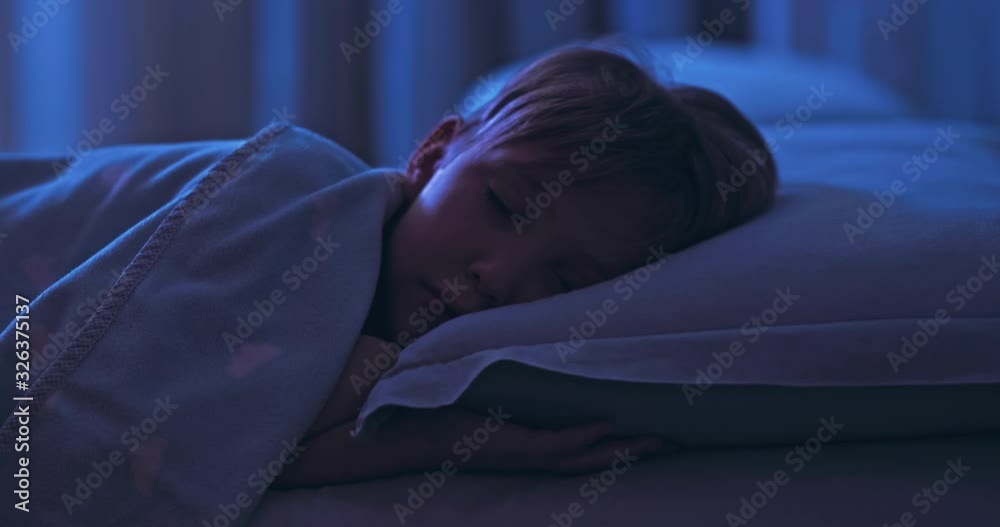 8 years old boy sweetly sleeping in his crib. Face close-up of a sleeping child on its side. Tracking shot of a sleeping kid at midnight. Relax and resting. 4k footage of a sleeping child in bed. 8 years old boy sweetly sleeping in his crib. Face close-up of a sleeping child on its side. Tracking shot of a sleeping kid at midnight. Relax and resting. 4k footage of a sleeping child in bed.