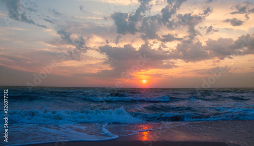 Beautiful gentle sunset on the seashore. Sunrise at sea. Waves and foam. Water Sunrise wave
