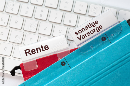 Roter und blauer Hängehefter mit Reitern und dem Text: Rente sonstige Vorsorge. Der Ordner liegt auf einem Computer Keyboard photo