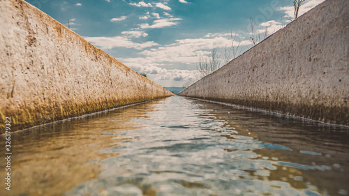 long line of straight canal with water