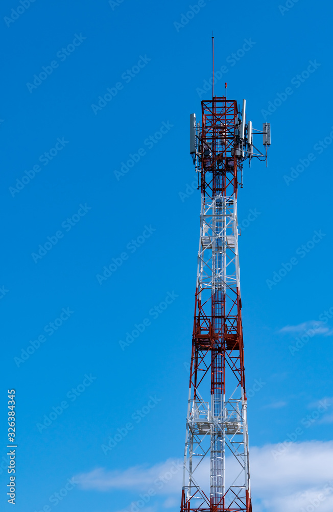 Telecommunication tower with blue sky and white clouds background. Antenna on blue sky. Radio and satellite pole. Communication technology. Telecommunication industry. Mobile or telecom 4g network.