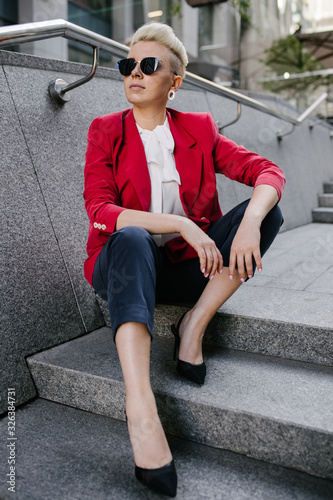 Girl in sunglasses sits on the steps