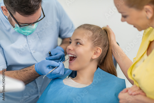 Dentist examining patient's teeth in clinic