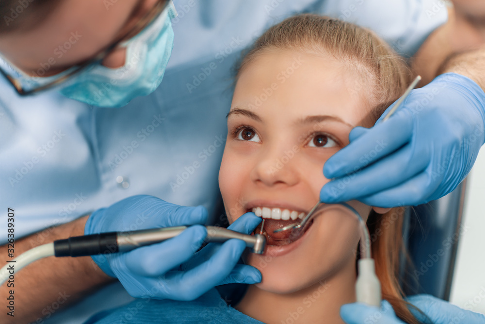Dentist examining patient's teeth in clinic Dentist examining patient's teeth in clinic