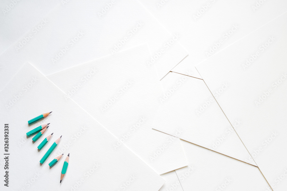 Naklejka premium Sheets of white paper and green pencils 