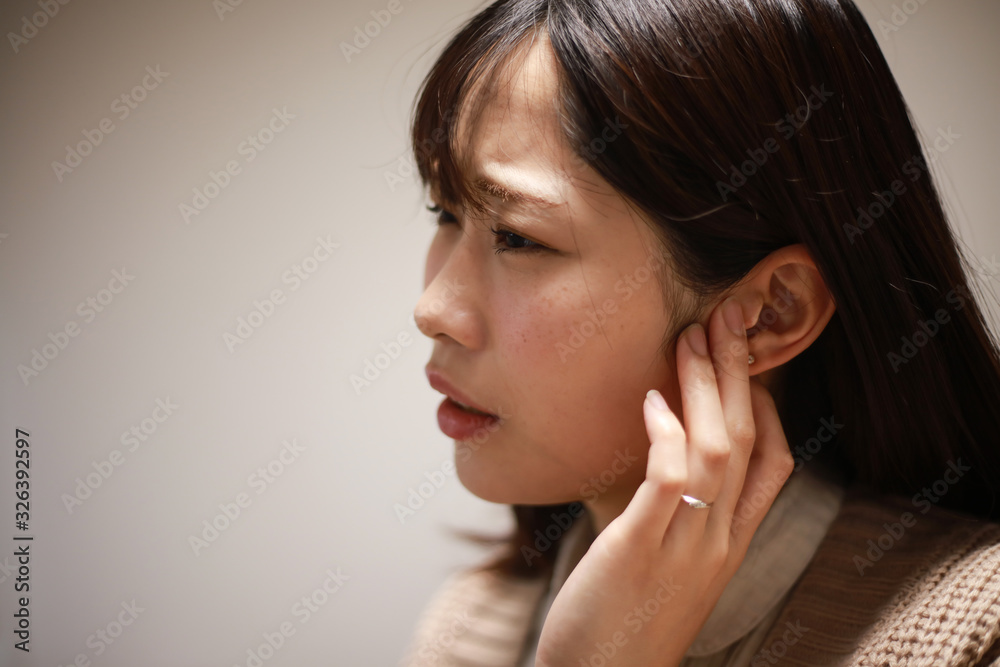 耳に違和感を感じる女性 耳に違和感を感じる女性