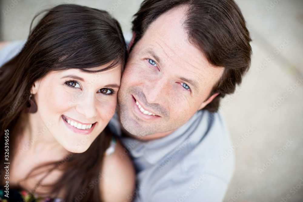 Happy Young Man and Woman Sitting Together Outside
