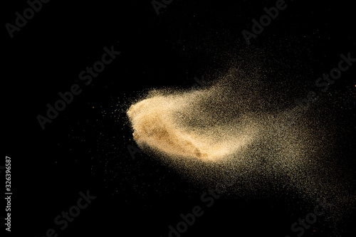 Brown colored sand splash.Dry river sand explosion isolated on black background. Abstract sand cloud.