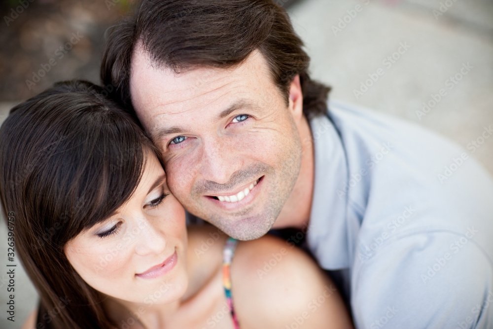Happy Young Man and Woman Sitting Together Outside