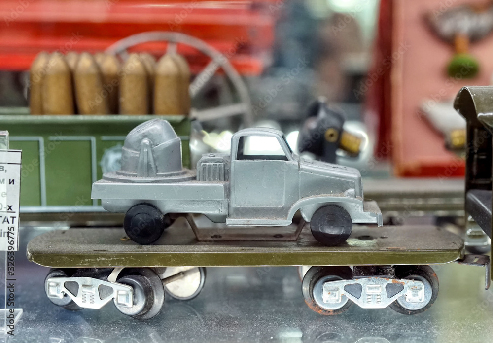 Military vehicle on the railway platform. Showcase with old toys in a retro toy store.