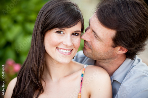 Happy Young Man and Woman Sitting Together Outside