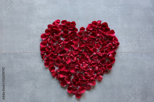 red rose petals heart on background