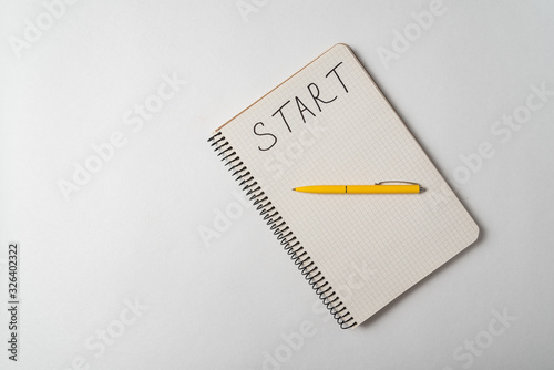 Start written on notebook over white background. Planning new business. Top view