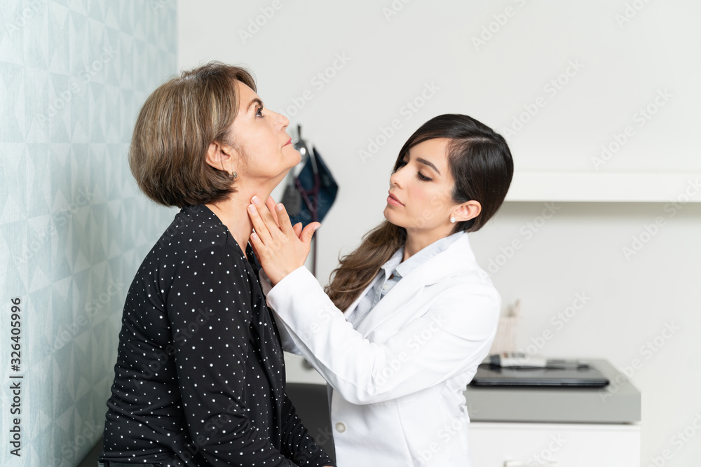 Female Doctor Examining Elderly Patient In Clinic