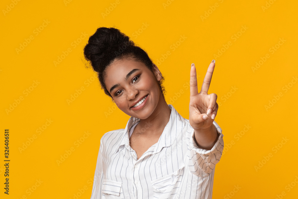 Afro girl showing peace, victory or number two gesture with fingers Afro girl showing peace, victory or number two gesture with fingers