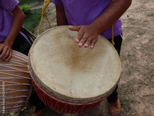 Human hand play music on drums outdoors.