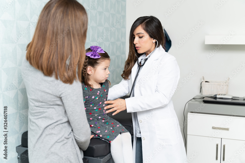 Fototapeta premium Confident Female Doctor Checking Cute Little Patient