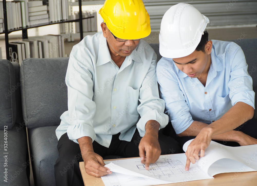 asian male engineer wear safety helmet or foreman and architects Asian people discussing blueprint of future building or check documents and business workflow. asian male engineer wear safety helmet or foreman and architects Asian people discussing blueprint of future building or check documents and business workflow.