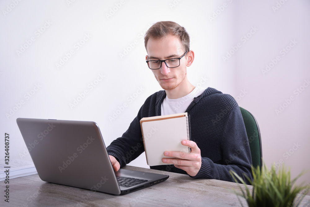 Portrait of young business man sitting at his desk desktop laptop technology in the office.Internet marketing, finance, business concept Portrait of young business man sitting at his desk desktop laptop technology in the office.Internet marketing, finance, business concept
