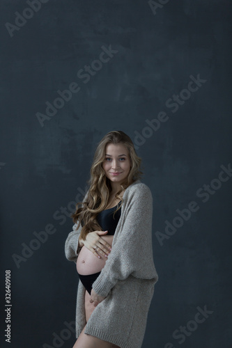 Pregnant happy Woman touching her belly. Pregnant middle aged mother portrait, caressing her belly and smiling close-up. Healthy Pregnancy concept, brunette expectant female