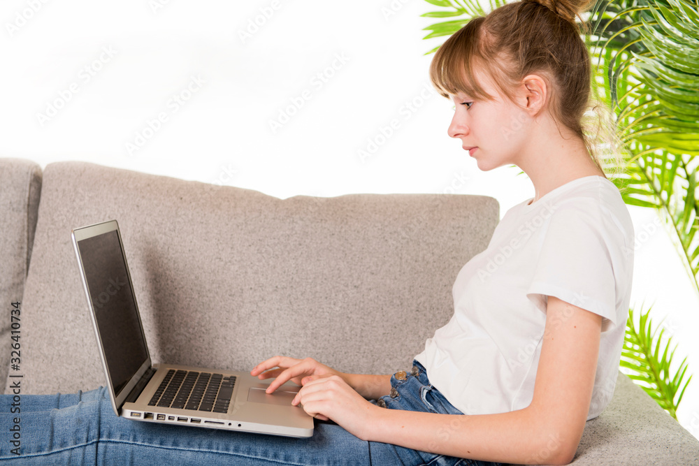 Naklejka premium Happy woman relaxing on cozy sofa with laptop in living room at home