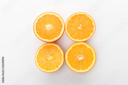 Top view of cut oranges on white background