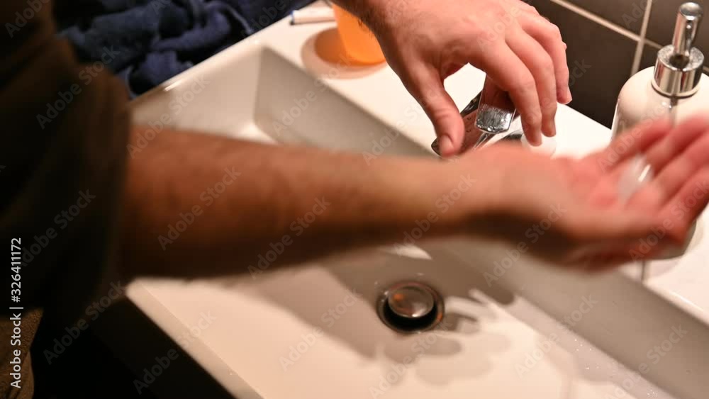 A Caucasian man washes his hands with soap and water to ward off virus infection A Caucasian man washes his hands with soap and water to ward off virus infection