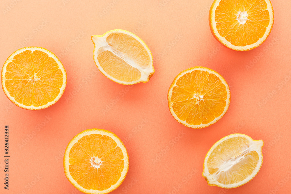 Fototapeta premium Top view of citrus fruits halves on orange background