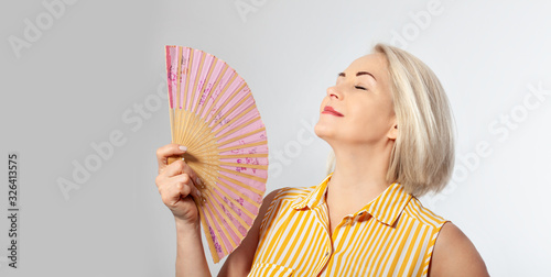 Canvastavla Attractive middle aged woman relaxing with fan
