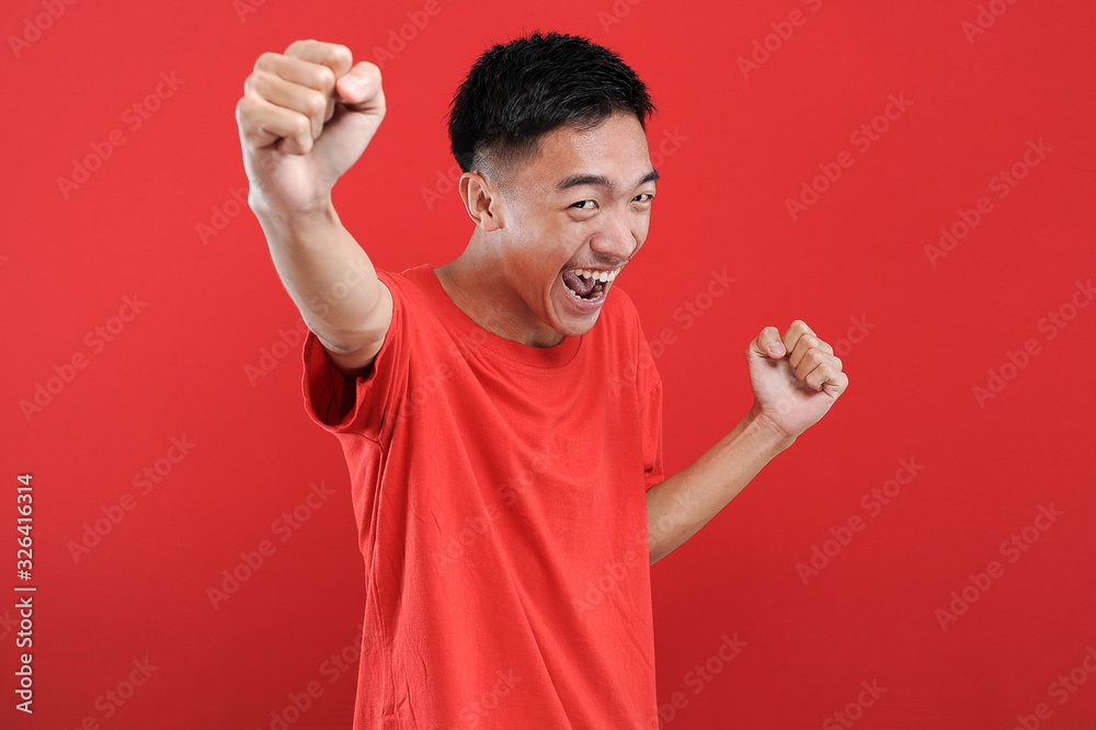 Fototapeta premium Young Asian teenager doing winning gesture, Happy get special gift