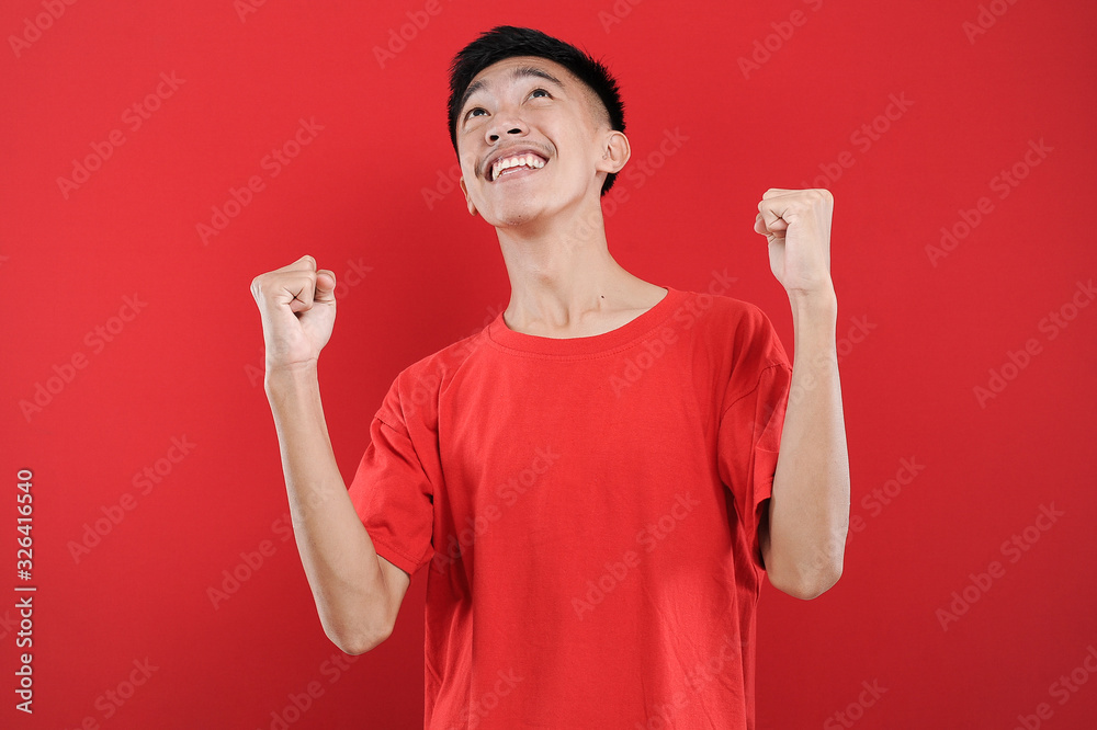 Young Asian teenager doing winning gesture, Happy get special gift Young Asian teenager doing winning gesture, Happy get special gift
