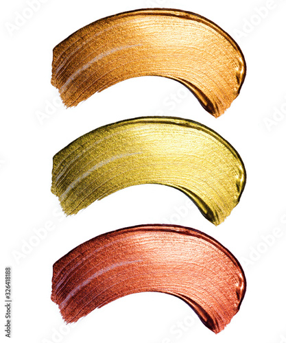 Creative brushstrokes of gold paint isolated on a white background. Gold paint texture.Acrylic gold paint. Smears of cosmetics, blush, highlighter, eye shadow, lipstick.