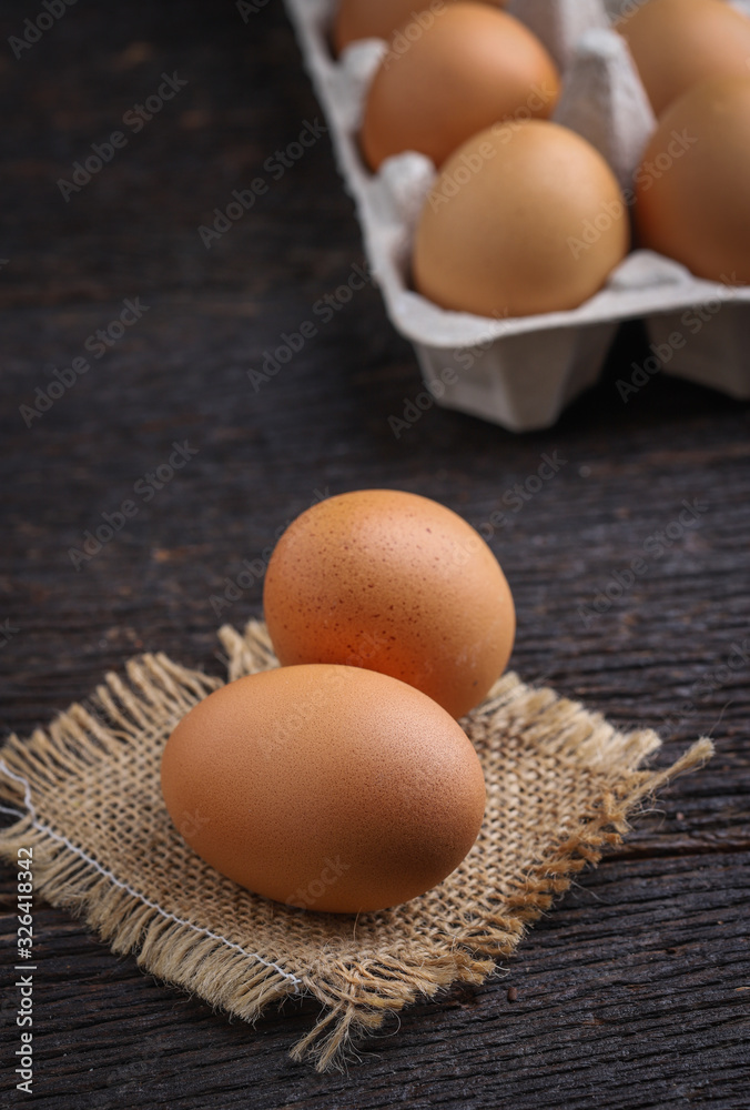 Raw eggs in egg box on rustic wooden background. Raw eggs in egg box on rustic wooden background.