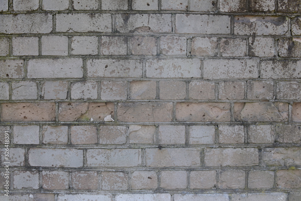 Old shabby, wrecked brick wall with grey cement mortar as background Old shabby, wrecked brick wall with grey cement mortar as background