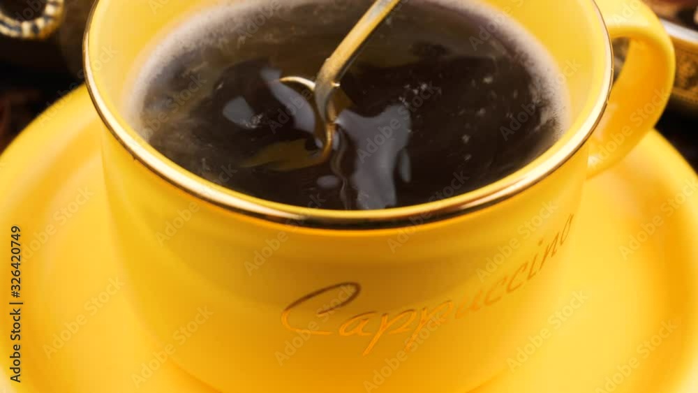 Stir coffee in a cup with a spoon. Stir coffee in a cup with a spoon.
