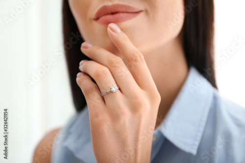 Young woman wearing beautiful engagement ring, closeup