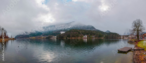 Panoramic view of Villa Castiglioni, the castle of Grundlsee, the largest lake in Styria, Austria, framed by the Dead Mountains, in misty winter morning
