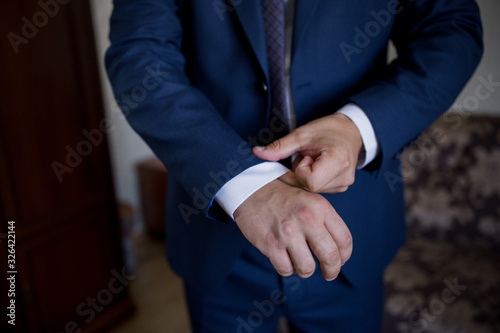 man in suit fastens his jacket