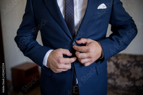 man in suit fastens his jacket