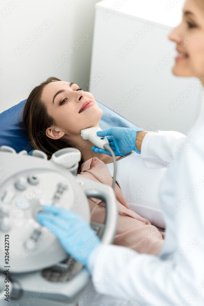 doctor examining thyroid of female patient with ultrasound scan in clinic doctor examining thyroid of female patient with ultrasound scan in clinic