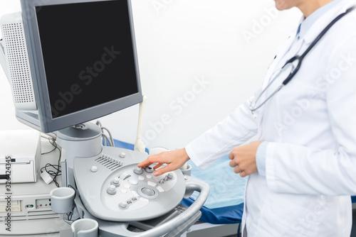 cropped view of doctor working with ultrasound scanner with blank screen