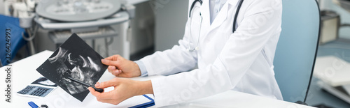 Valokuva panoramic shot of female doctor showing ultrasound scan in clinic