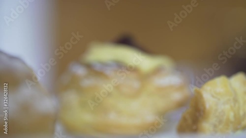 Closeup backlit of a woman getting a tasty bignè with black cherry and soft cream. Pastries. Cream puffies. Italian zeppole di San Giuseppe. photo