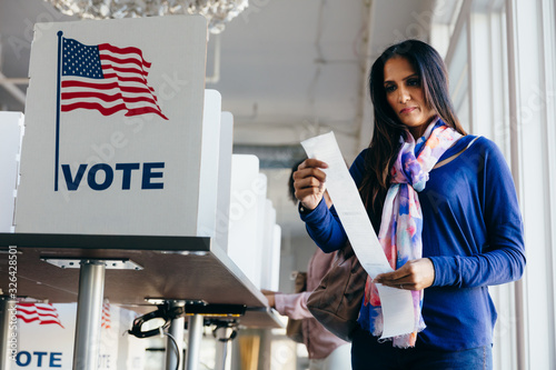 Woman checking paper ballot voting receipt