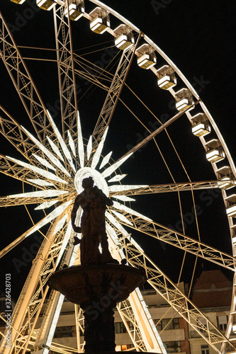 Budapest Eye ferris wheel at night with Danube fountain figure photo