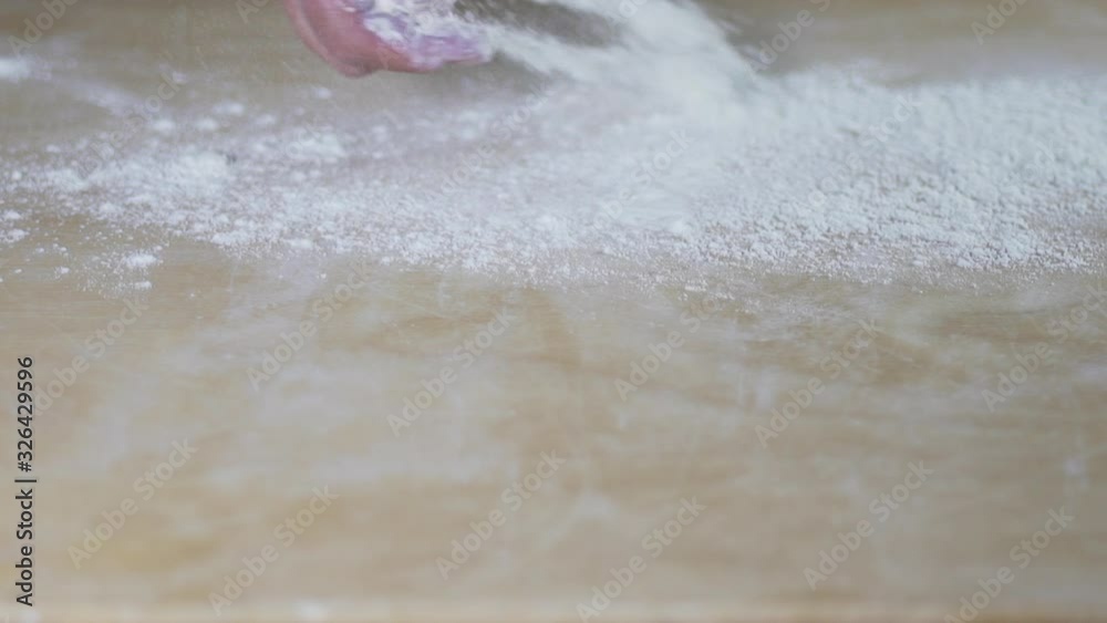 Close up shot of woman chef cook baker preparing bread or pizza, throwing flour on a wooden board in slow motion and clapping hands. Food concept. Close up shot of woman chef cook baker preparing bread or pizza, throwing flour on a wooden board in slow motion and clapping hands. Food concept.