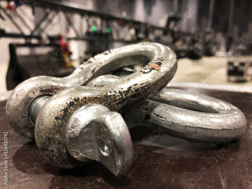 Steel rigging shackles on flight case. Metal truss with light and sound equipment. photo