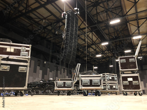 Installation of professional sound speakers, line array, light, video and stage equipment for a concert. Tech zone with flight cases. photo